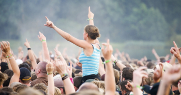 Rock-Fans feiern unter freiem Himmel im Sommer bei einem Musikfestival